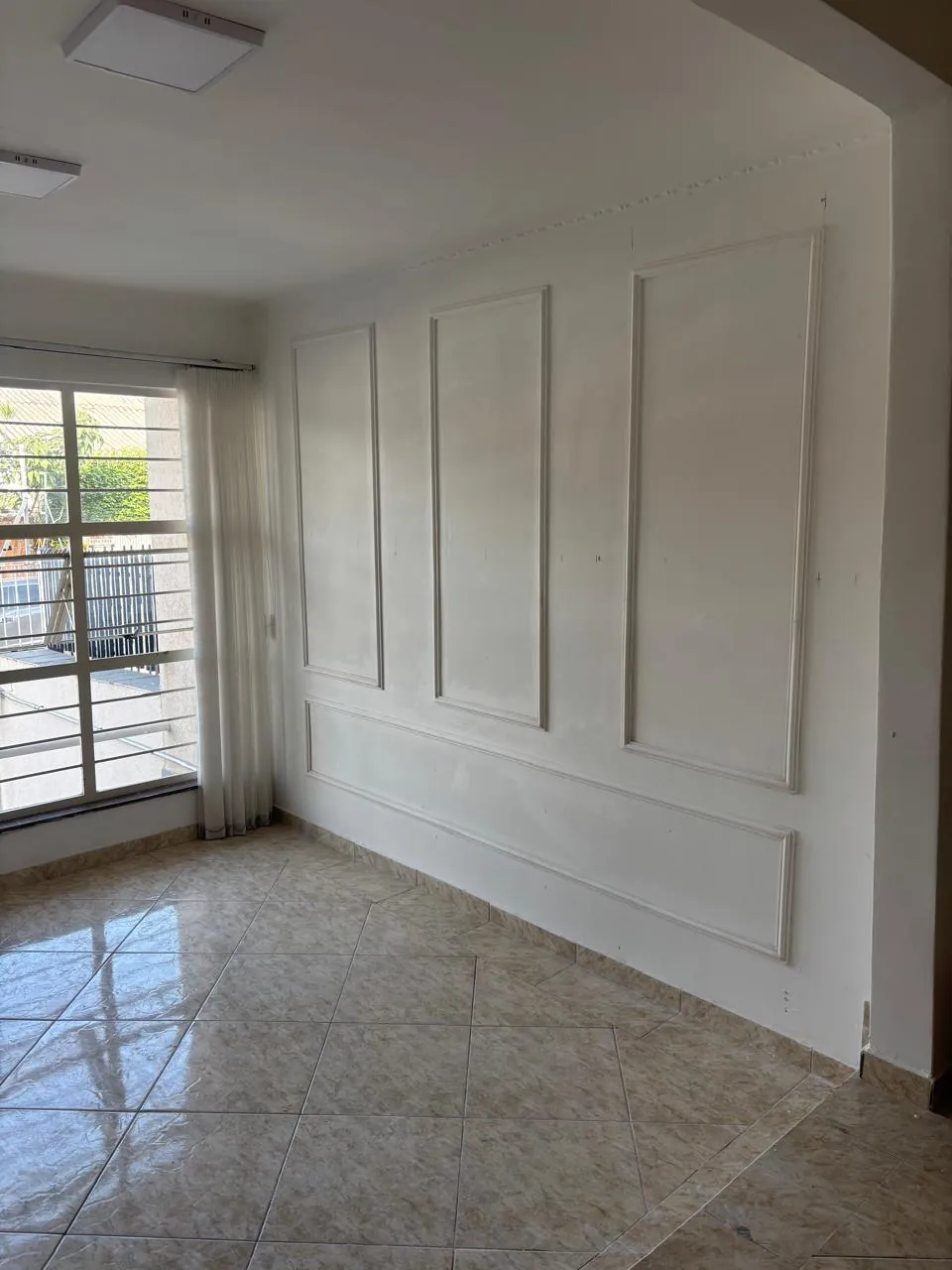 Sala finalizada com boiserie em gesso, molduras e luz natural